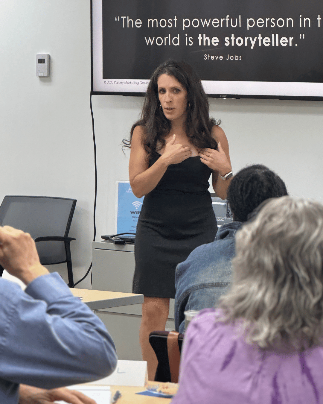 Photograph of Julie Paisley, a female keynote speaker, speaking to a group of people.